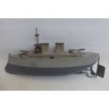 A Sutcliffe tinplate model of a warship.