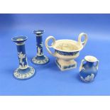 A pair of Wedgwood blue jasper dip Candlesticks, applied in white with classical figures and