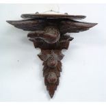 A Black Forest carved Bracket, in the form of an eagle and pomegranates, 18in (46cm) high.