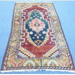 Tribal Rugs; a maroon ground Persian Rug with pink motif within a sea-green central medallion,