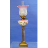 A Victorian brass Oil Lamp, the pink glass reservoir decorated in enamels with harps and