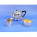 A near matched Victorian silver three piece Tea Set, the teapot and cream jug by Army & Navy