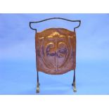 An Arts & Crafts copper and wrought iron Fire Screen, the copper panel repoussé decorated with a