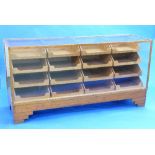 An Art Deco style vintage glazed Haberdashery Counter by Dudley & Co. Ltd., oak framed with