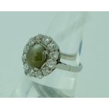 An attractive chrysoberyl and diamond Dress Ring, the centre set with an oval chrysoberyl surrounded