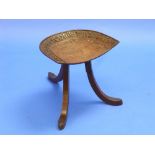 A Liberty & Co. oak Thebes stool, the dished seat layer carved with the portrait of an Egyptian