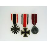 A W.W.2 German Iron Cross medal, 2nd Class, 1913 / 1939, together with two other W.W.2 German