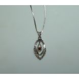 An 18ct white gold Pendant and Chain, the shaped openwork centre with a small garnet centre,