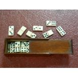 Dominoes; an antique set of twenty-eight miniature hand-carved bone dominoes, in mahogany box with