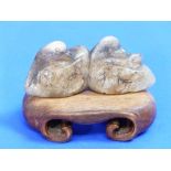 An early 20thC oriental jade group of two Ducks, on carved wood stand, 4½in (11.5cm) wide,