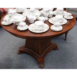 A circular Gueridan table with burr centre and mahogany crossbanded edging, supported on large