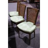 A set of eight Continental fruitwood dining chairs with cane backs, green diamond patterned