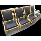 Four gilded open armchairs with black leather upholstery, scrolling arms and tapering legs (4).