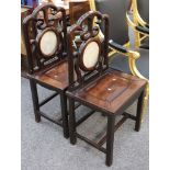 A pair of antique Chinese hardwood side chairs, the backs set with circular marble planes.