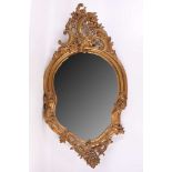 A Rococo style gilt framed mirror, pierced pediment to top and cherubs to side, 104cm high x 55cm