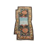 An early 20th Century Tibetan saddle rug, 1.25m x 0.62m, condition rating A/B.