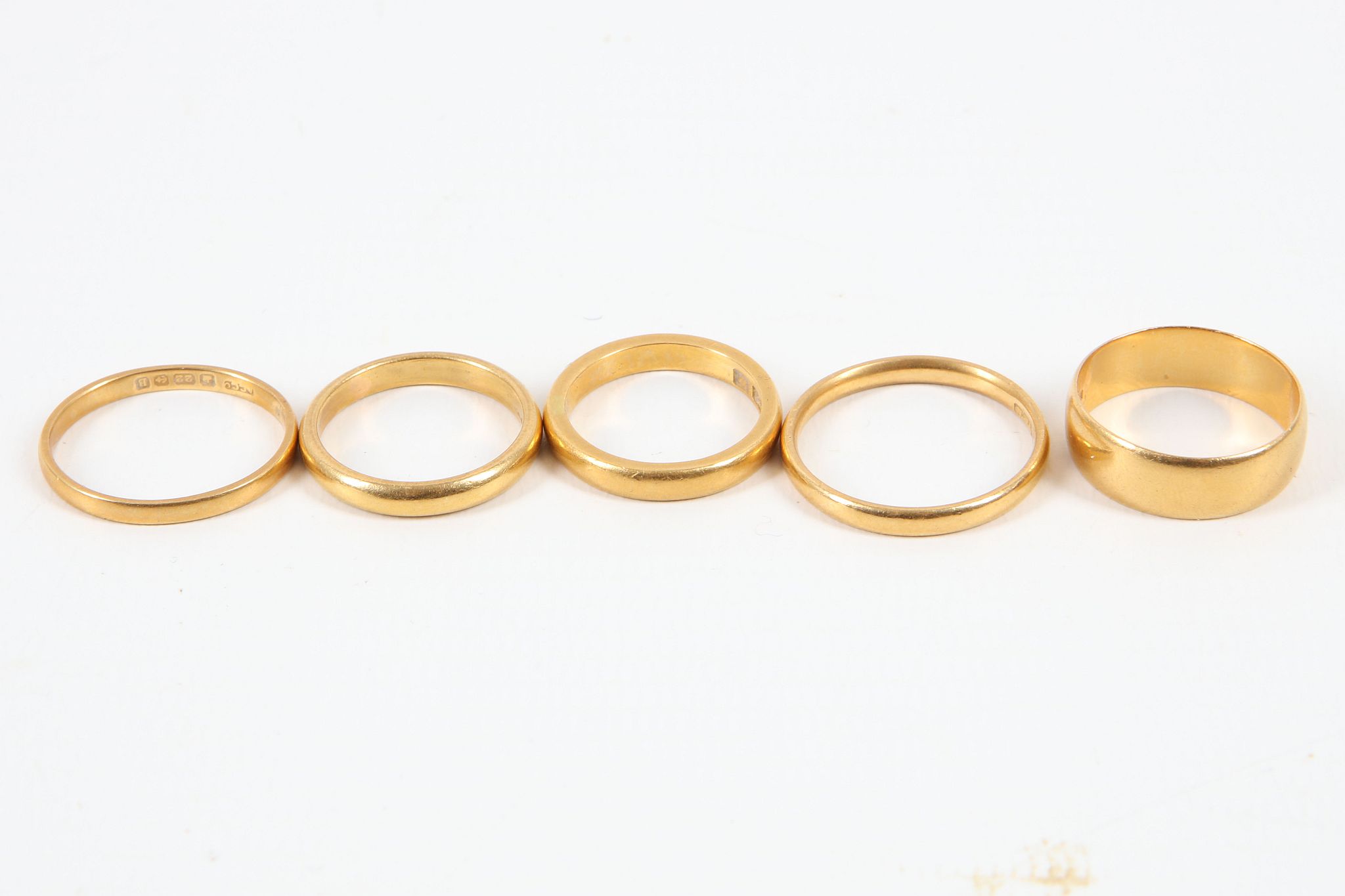 Five 22ct gold wedding bands, various sizes.