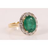 An emerald and diamond cluster ring, the oval shaped mixed cut emerald weighing 3.58cts, claw set