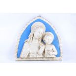 An Italian lancet shaped moulded plaque with the Madonna, in cream on blue ground, in the manner