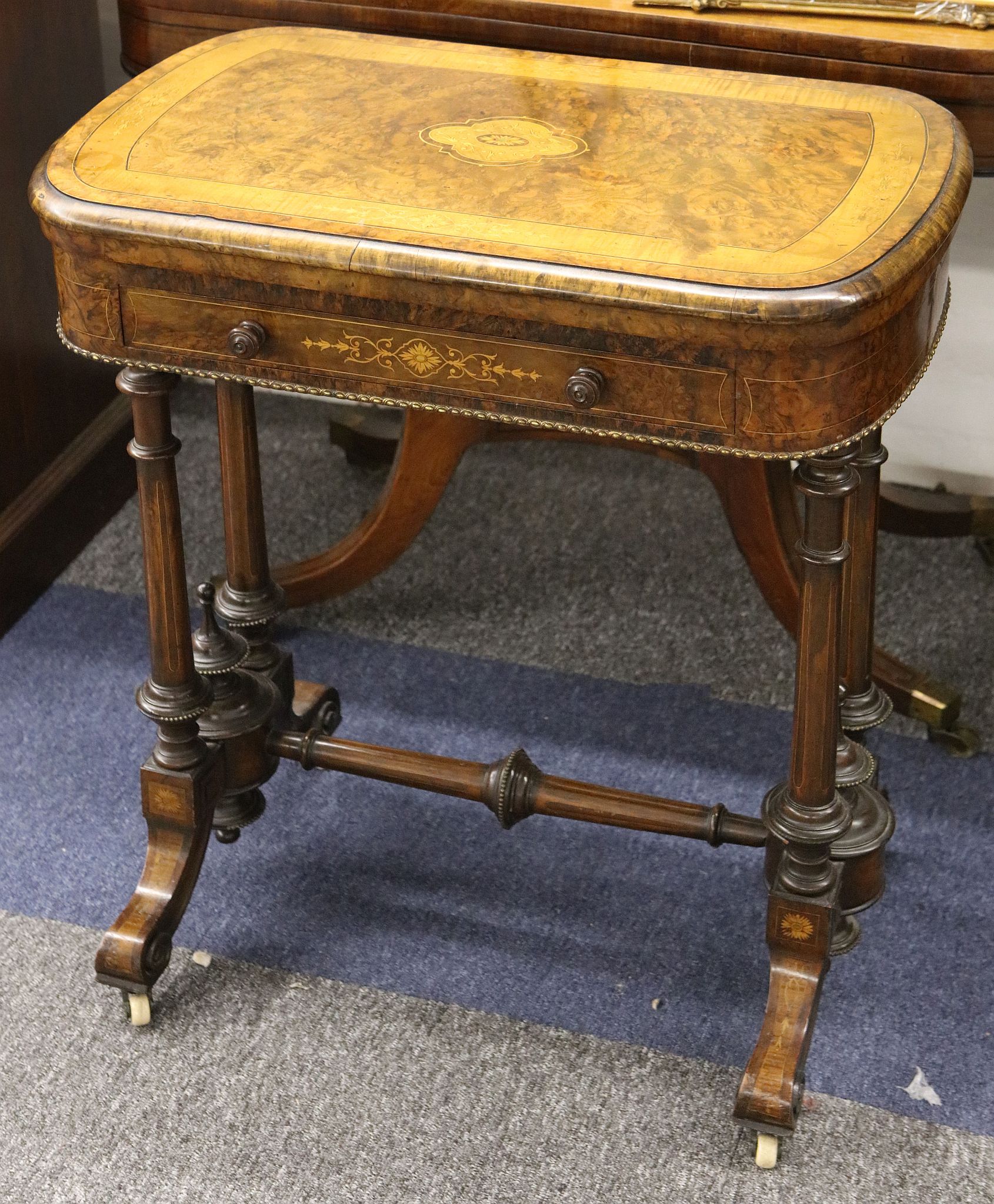 A fine mid 19th Century Victorian burr-walnut game table, the hinged top inlaid with scrolling