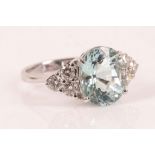 An aquamarine and diamond dress ring, the oval shaped mixed cut aquamarine weighing 4.40cts, claw