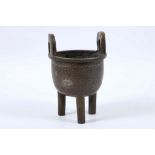 A bronze tripod censer with a band of geometric pattern around the body, loop handles on the rim,