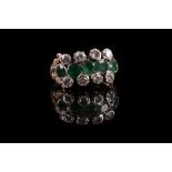 An antique style emerald and diamond ring, set with central band of 5 emeralds flanked by four