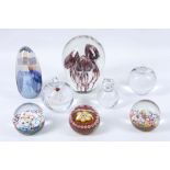 A small collection of glass paperweights to include Murano milliefore examples, a Baccarat cat,