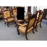 An unusual set of four mahogany dining armchairs of substantial size, with carved frames, leather