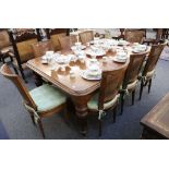 A late 19th Century mahogany dining table with extra leaves, rounded corners, supported on carved