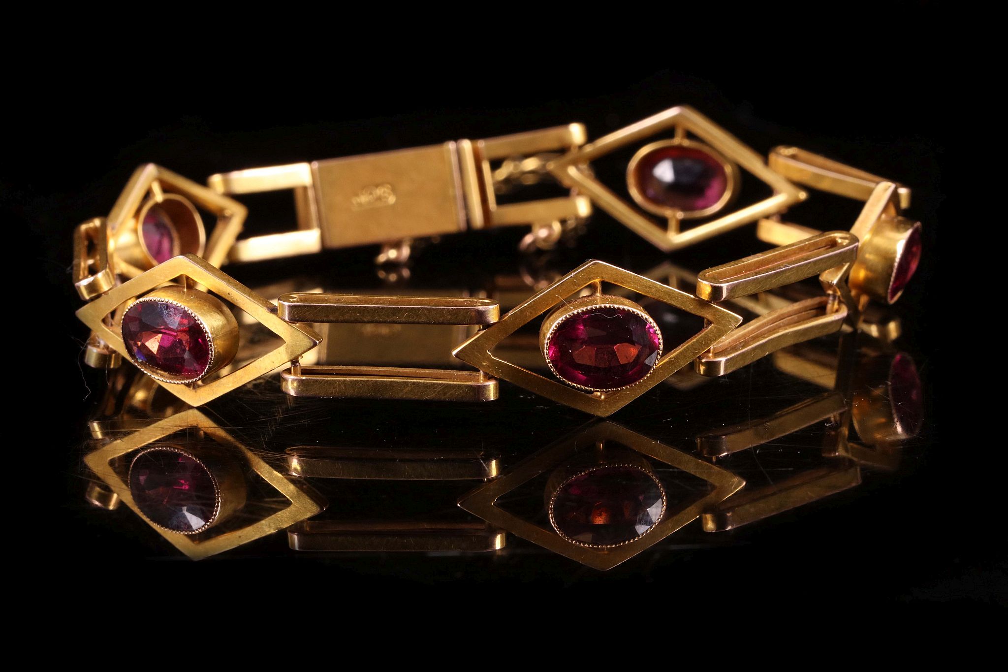 An antique yellow gold and almandine garnet bracelet c.1900, the gate link bracelet with five