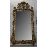 A good antique giltwood pier mirror, the complex frame carved with tambourine, horn and various