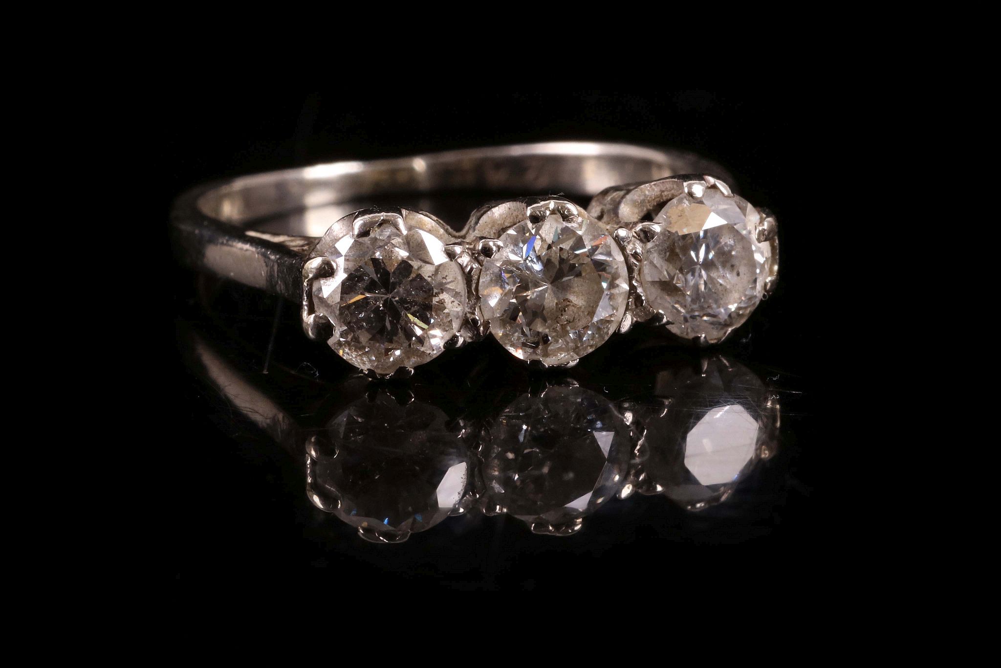 A diamond three stone ring c.1930, set with three uniform sized brilliant cut diamonds, claw set