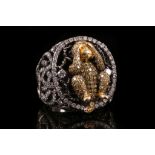 An 18ct gold and diamond set dress ring, centred with a figure of a monkey covering its eyes.