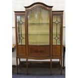 An Edwardian mahogany bow fronted display cabinet, with central glazed door on square tapering