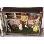 A dolls house dirorama, with figures and furniture.