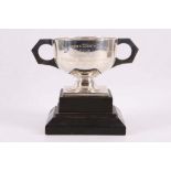 A silver trophy cup, with twin handles on square ebonised base, Birmingham 1928.