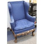 An early 20th Century George III style mahogany wing armchair, upholstered in dark blue, cabriole