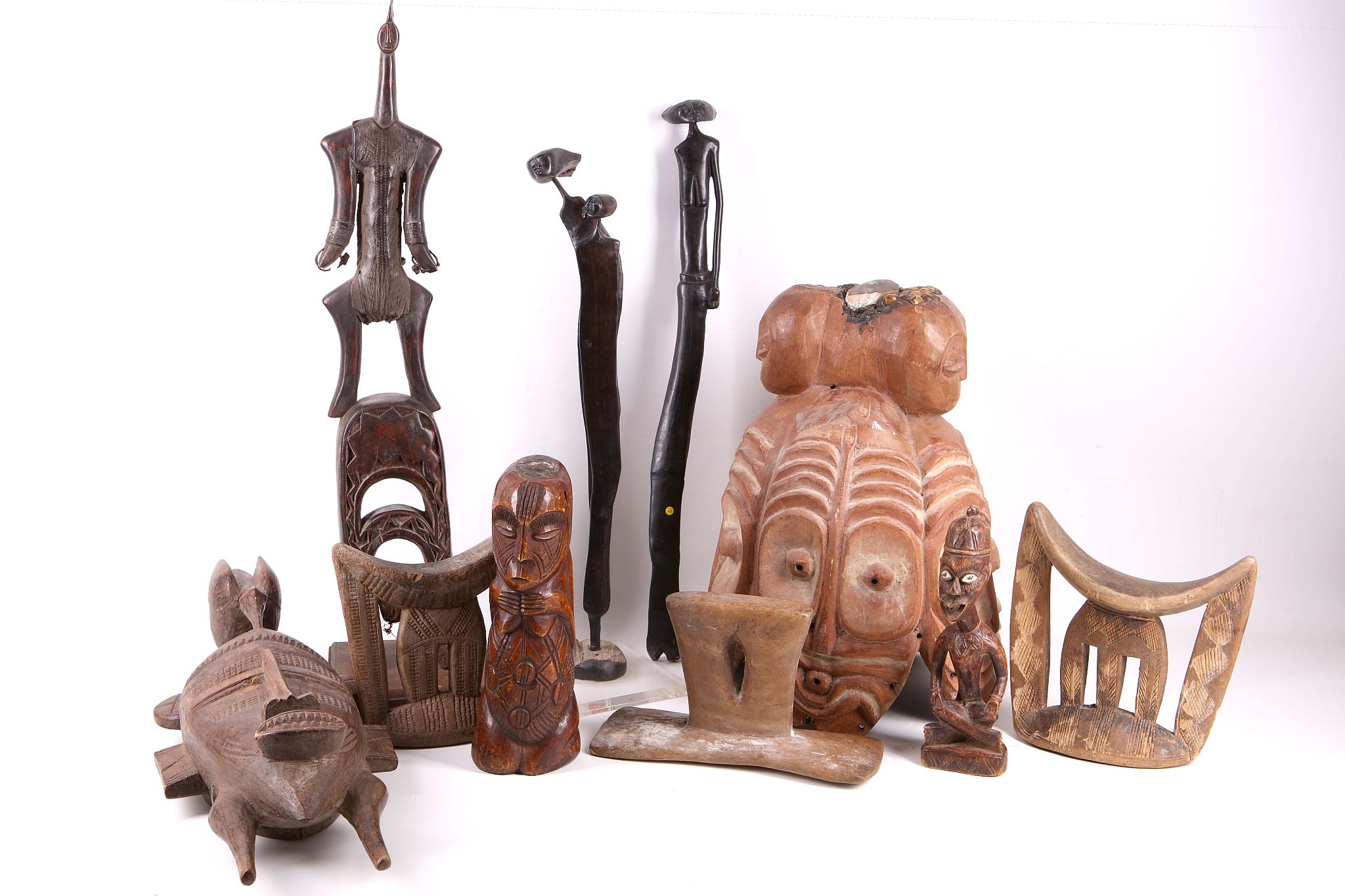 A collection of 10 African tribal items to include a helmet, pulley, 3 headrests etc (10).