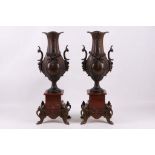 A pair of bronzed spelter vases on range marble pedestals, 47cm high (2).