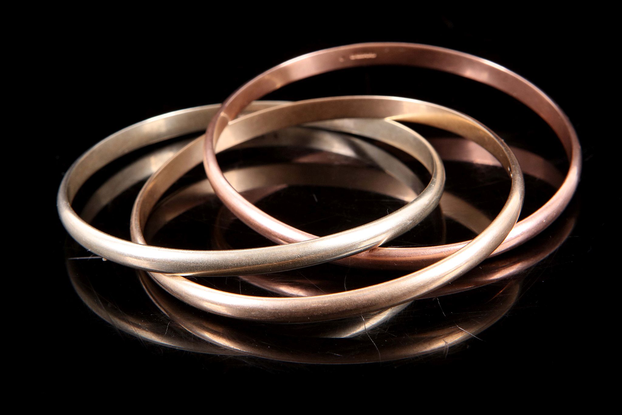 A group of nine carat tri coloured gold 'Russian' style bangles, approximate total weight 60 grams