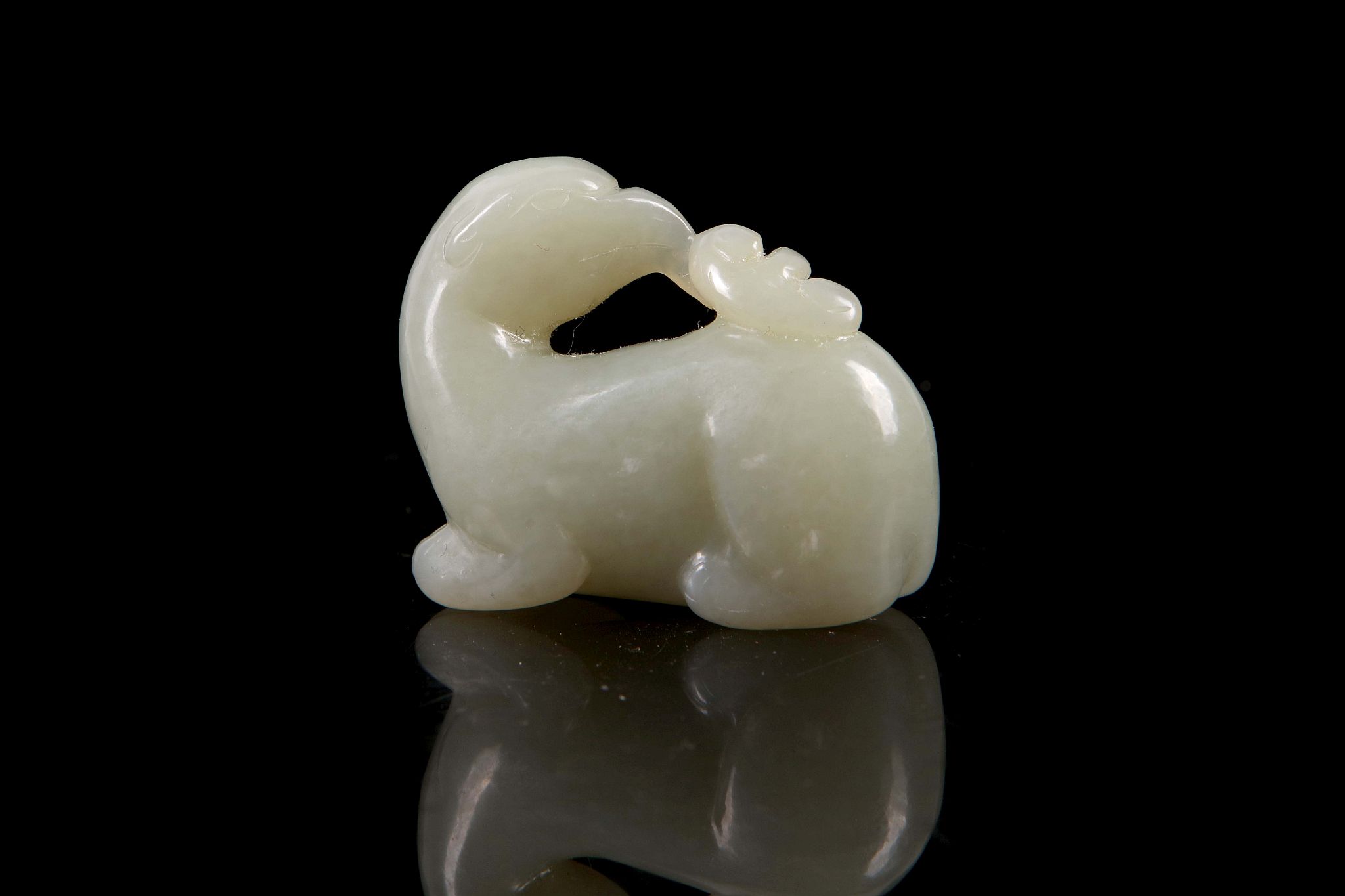 A Chinese jade carving of a mythical beast with bird of prey head.