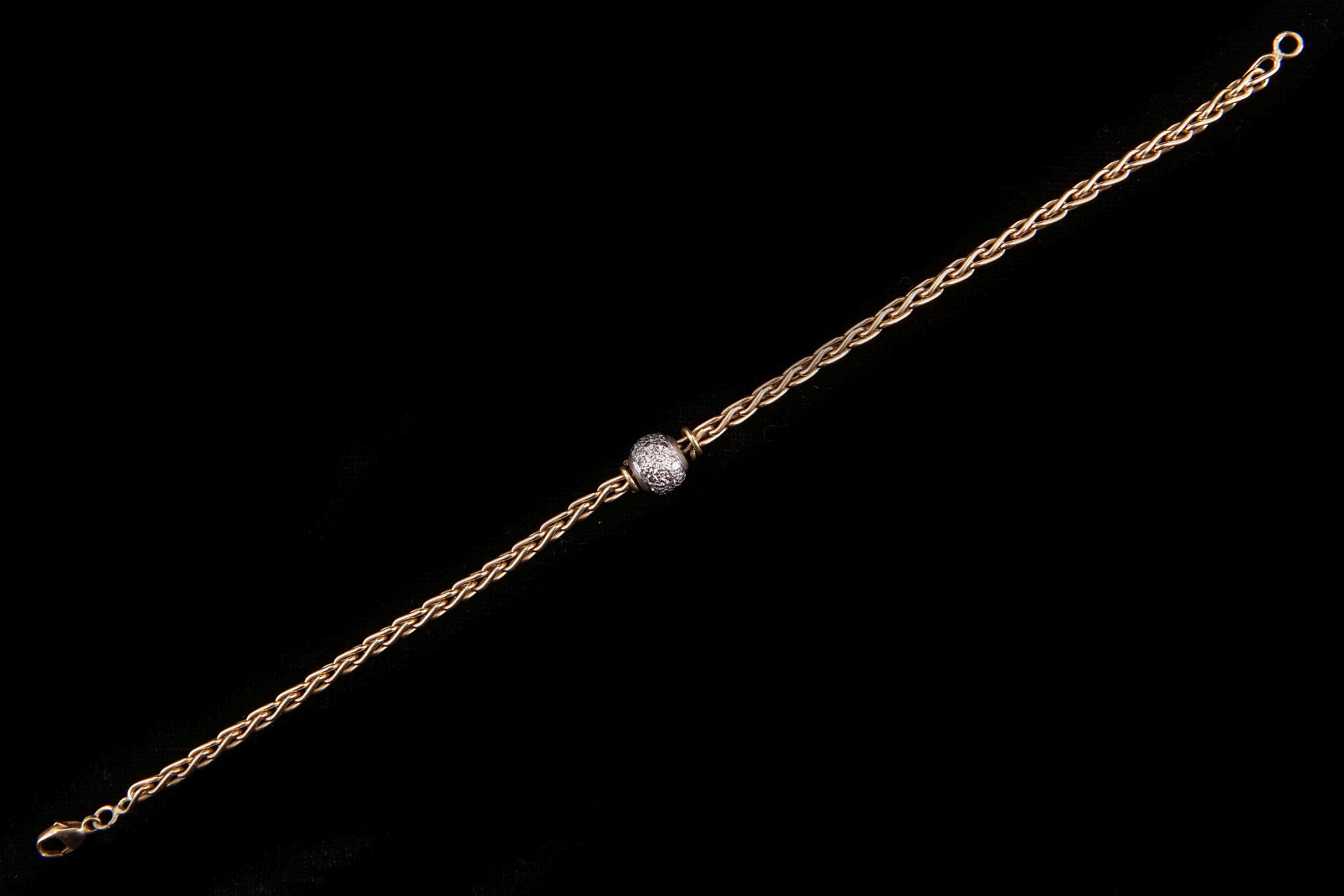 An 18 carat gold and diamond ball bracelet, the foxtail link chain with a pave set diamond ball to