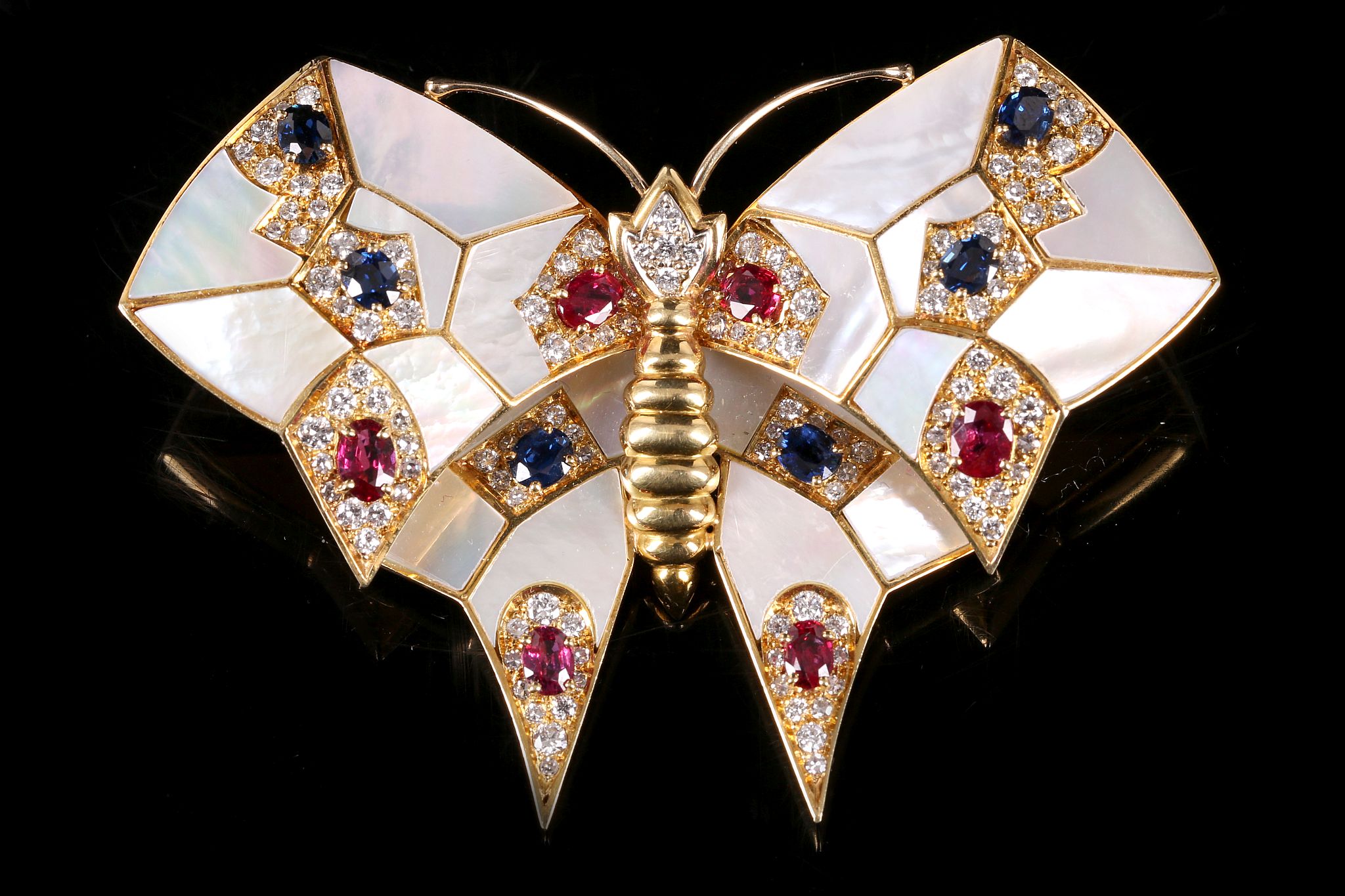 A mother-of-pearl, sapphire, ruby and diamond butterfly brooch The mother-of-pearl wings accented by