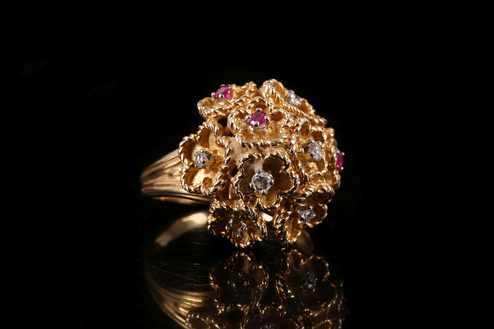 A yellow gold, diamond and ruby dress ring c.1960, designed as a multi flower cluster, each flower