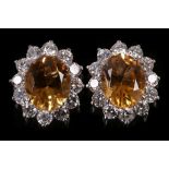 A pair of citrine and diamond cluster earstuds Each oval-cut citrine within a surround of