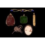 A collection of jewellery Including a pendant with Egyptian figures, a green hardstone pendant, a