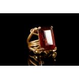 A synthetic dark red gemstone ring The step-cut synthetic dark red gemstone, in a four-claw setting,