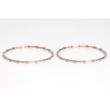 A pair of diamond-set bangles Each polished hoop accented at intervals with brilliant-cut diamonds