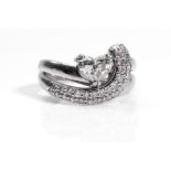 A diamond dress ring The heart-shaped diamond, accented by a curved line pavè-set with brilliant-cut